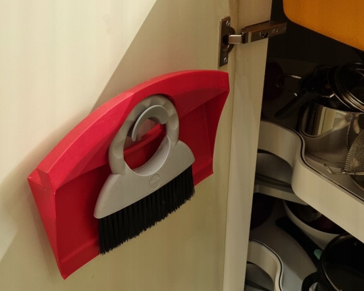 Hailo Kehrset mit Handschaufel und Handfeger, montiert an der Innenseite einer Schranktür zur platzsparenden Aufbewahrung.
