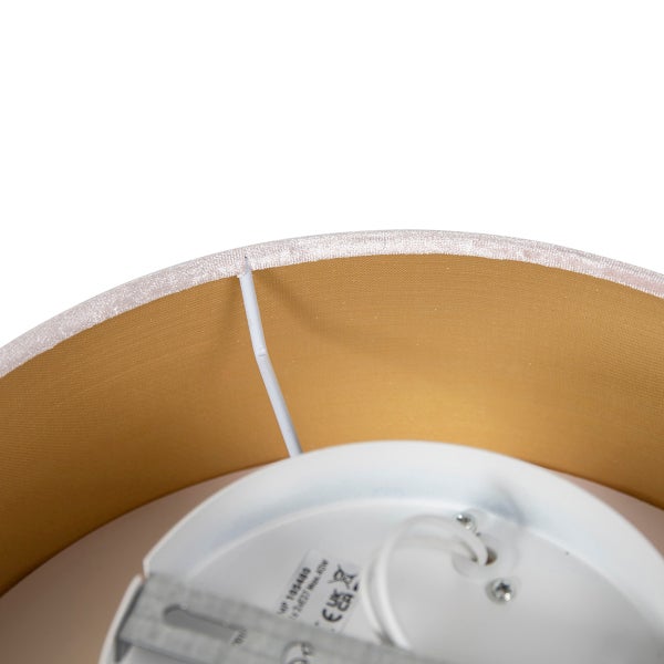 Detailansicht der goldenen Innenseite eines Lampenschirms mit Halterung und weißem Gehäuse.