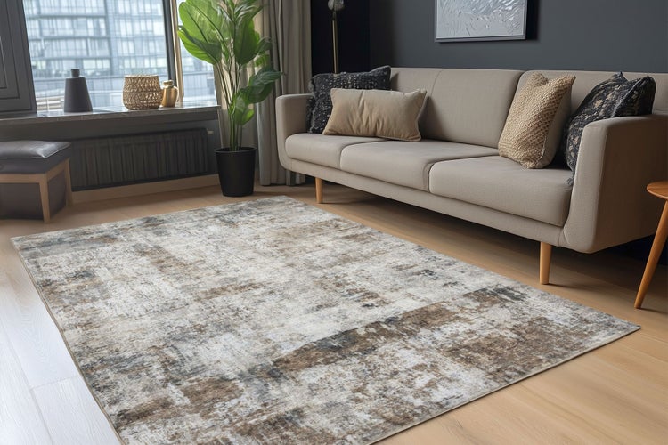 Wohnzimmer mit modernem Sofa und einem rechteckigen Teppich mit abstraktem Muster auf hellem Holzboden.