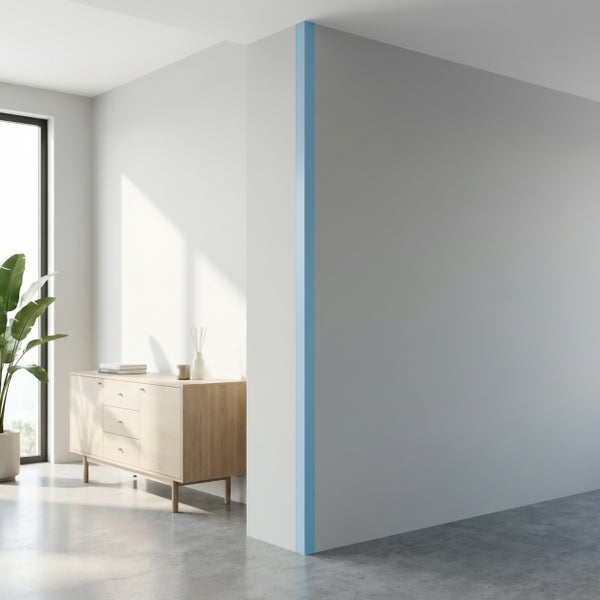 Moderne Wand mit Eckschutzprofil in einem hellen, minimalistisch eingerichteten Wohnraum mit Holzkommode und Zimmerpflanze.