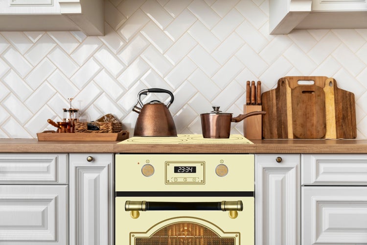 Offener Backofen mit Innenraumansicht, inklusive Backblech und Grillrost sowie einem mittig platzierten Lüfter für die Heißluftfunktion.