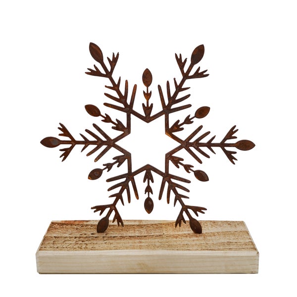 Dekorative Schneeflocke aus Metall in Edelrost-Optik auf einem rechteckigen Holzsockel für winterliche Dekorationen.