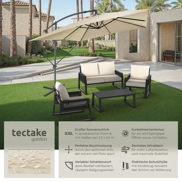 Große Personengruppe sitzt an einem Tisch unter einem Sonnenschirm im Garten.