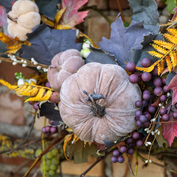 Dekoration mit Stoffkürbissen, Beeren und Blättern für Herbst