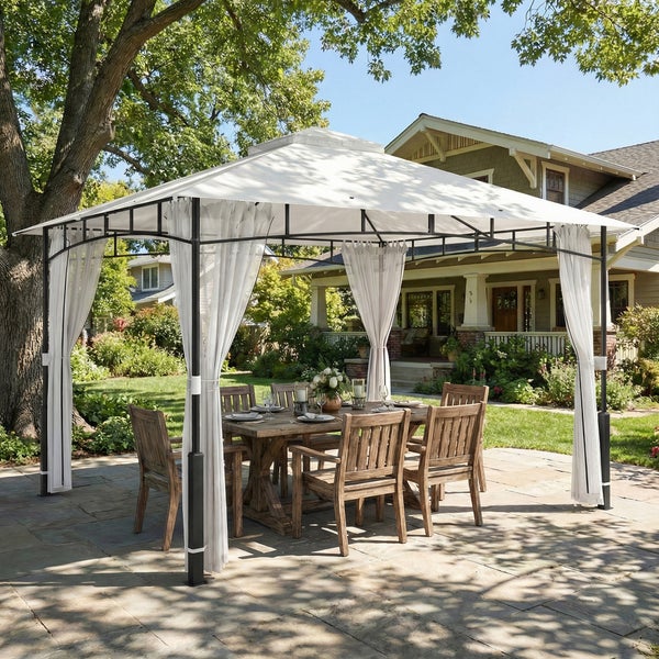 Gartenpavillon mit weißem Stoffdach, hellen Vorhängen und dunklem Metallgestell über einer hölzernen Essgruppe auf einer gepflasterten Terrasse.