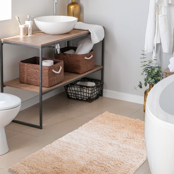 Badezimmer mit Waschtisch, Körben und Badteppich