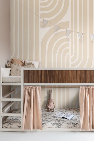 Etagenbett im Kinderzimmer mit Vorhängen, Kissen und Stofftier auf dem Bett