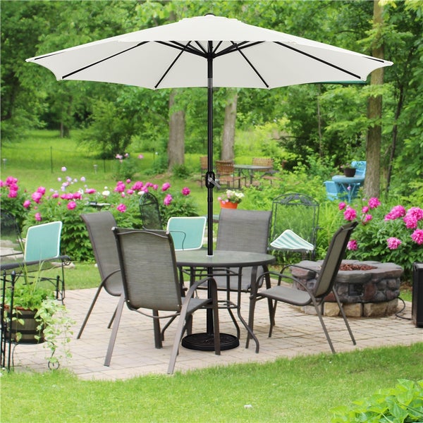 Gartenszene mit Sonnenschirm, Gartentisch und Gartenstühlen auf einer Terrasse