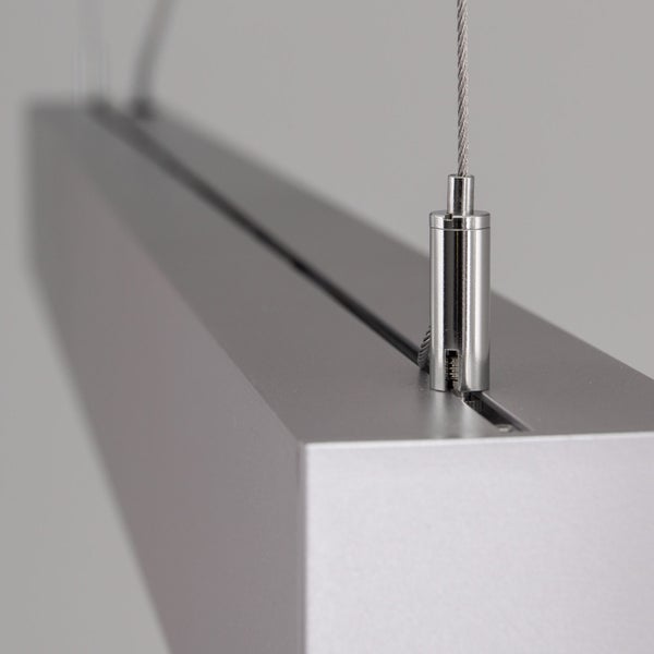 Detailansicht einer modernen Pendelleuchte aus Metall mit Drahtseilaufhängung