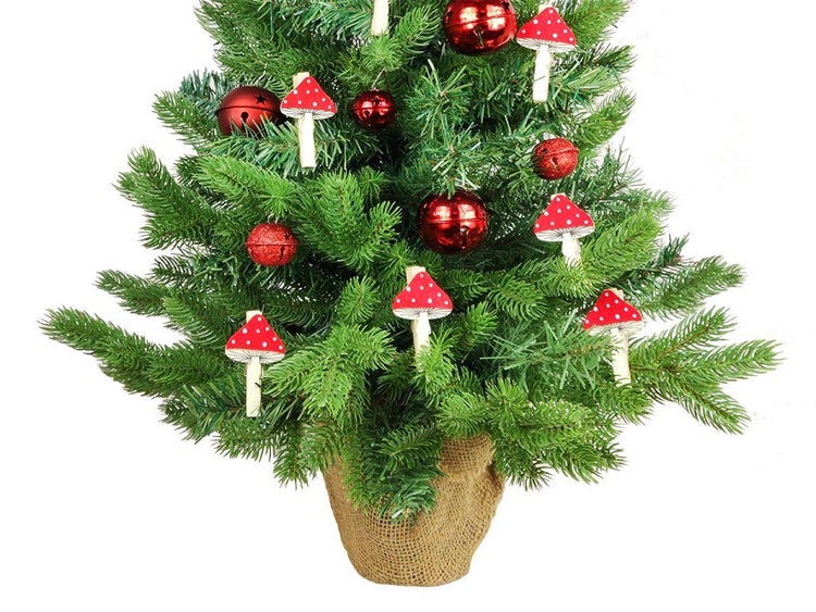Weihnachtsbaumdekoration mit Holzpilzclips an einem künstlichen Tannenbaum in einem Jutesack.