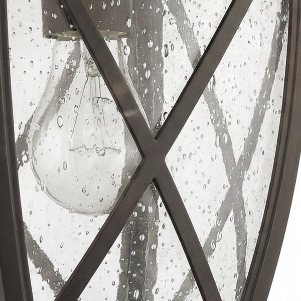 Nahaufnahme einer Außenleuchte mit einer klaren Glühbirne und einem dekorativen Metallgitter