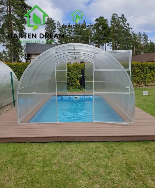 Bogenförmige Poolüberdachung aus Polycarbonat mit Metallrahmen auf einer Holzterrasse über einem Schwimmbecken im Garten. Garten Dream Logo.