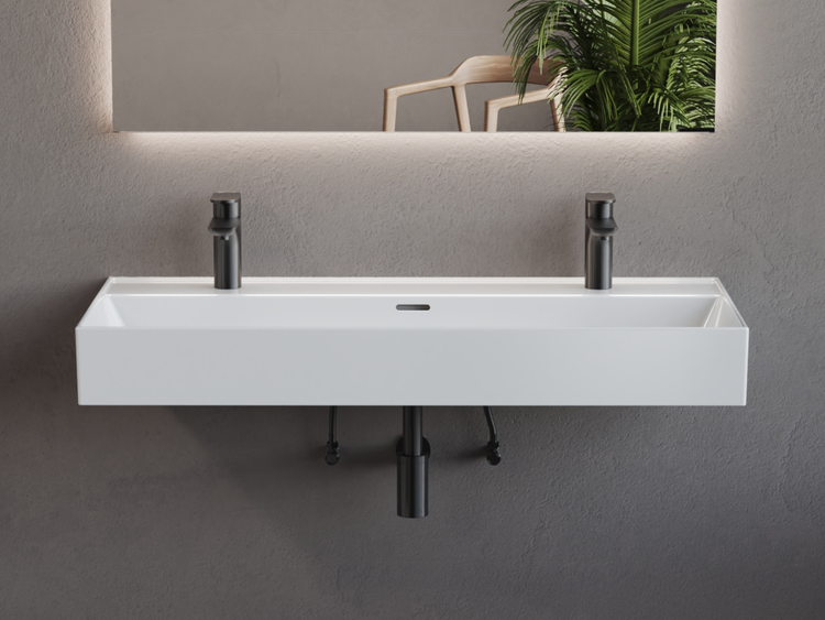 Modernes Doppelwaschbecken in Weiß mit zwei schwarzen Armaturen und beleuchtetem Spiegel vor einer grauen strukturierten Wand.