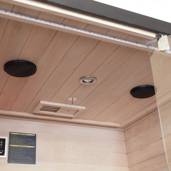 Detailansicht der Saunadecke aus Holz mit integrierten Lautsprechern, Beleuchtung und Lüftungsschlitz.