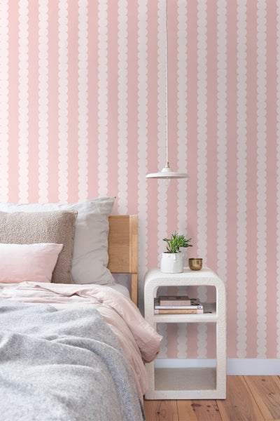 Ein Schlafzimmer mit einem Bett, einem Nachttisch und einer gestreiften Tapete