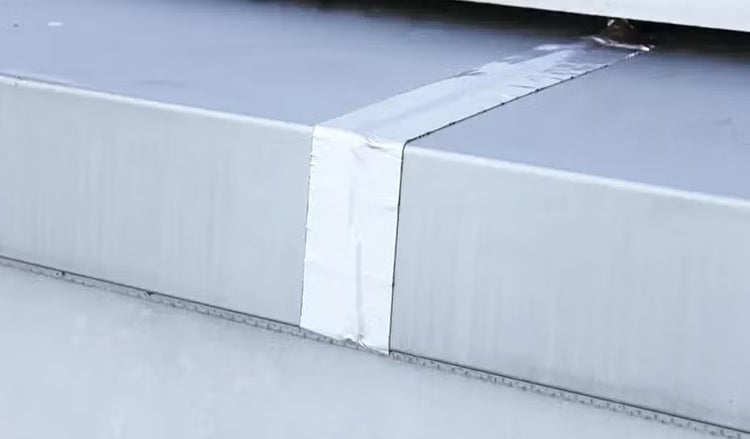 Ein selbstklebendes Aluminiumdichtband zur Abdichtung von Fugen und Rissen auf einer metallischen Oberfläche.