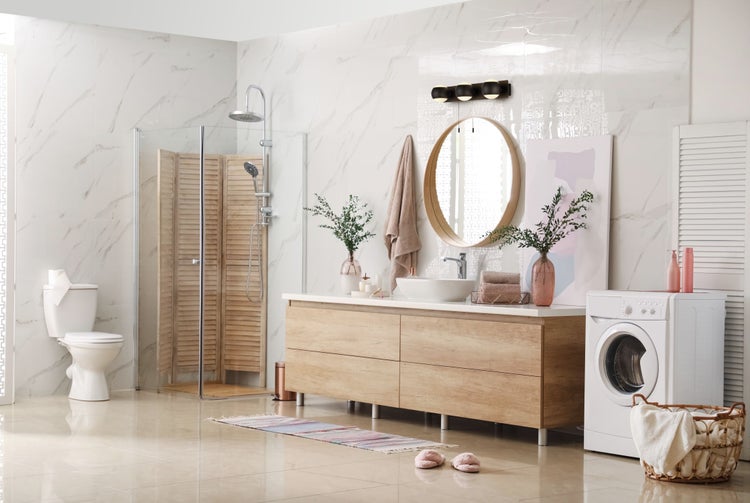 Helles Badezimmer mit Dusche, Waschbeckenunterschrank, Toilette und Waschmaschine