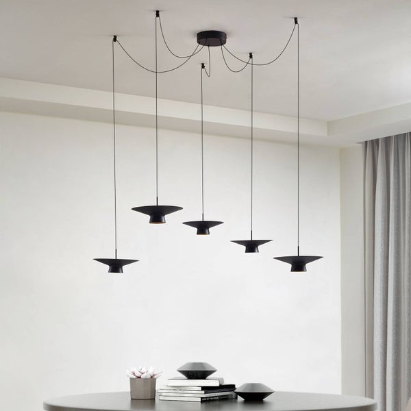 Fünfflammige Pendelleuchte in Schwarz über einem Tisch. Die flachen, kegelförmigen Schirme sind in unterschiedlichen Höhen an Kabeln aufgehängt.