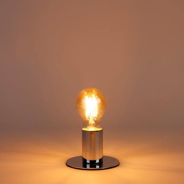 Leuchtende LED-Filament-Glühbirne in einer zylindrischen Metallfassung auf einem runden Standfuß mit warmem Licht.