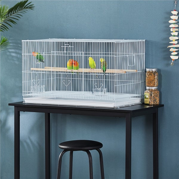 Vogelkäfig aus Metall mit mehreren Vögeln auf einem Tisch