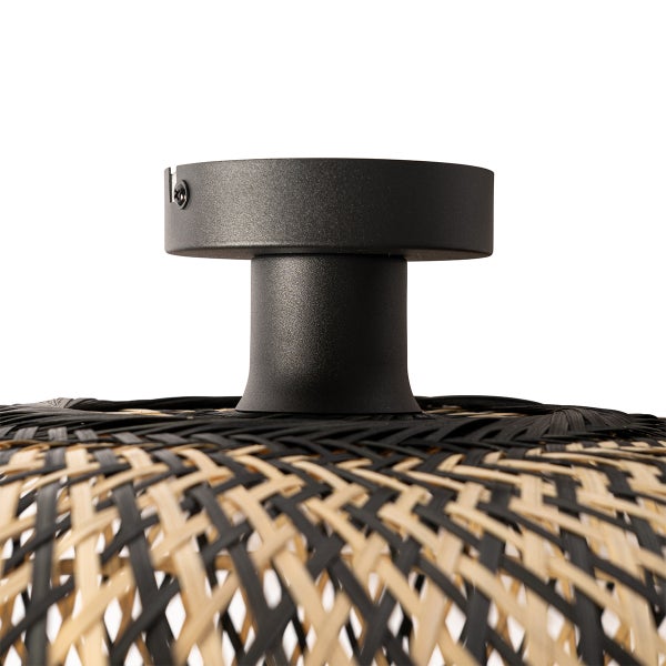 Detailansicht einer Deckenleuchte mit schwarzer Halterung und Lampenschirm aus geflochtenem Rattan.