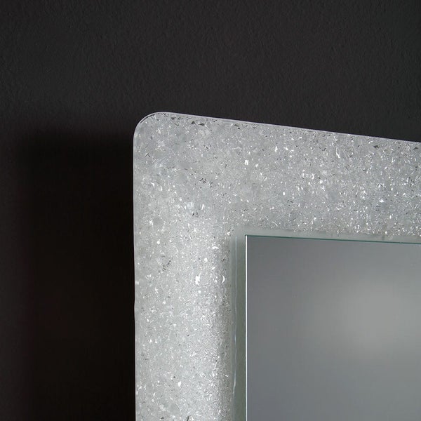 Detailansicht eines Wandspiegels mit einem breiten Rahmen aus lichtdurchlässigem Crashglas und abgerundeten Ecken.