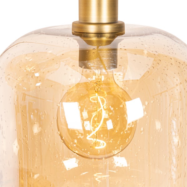 Nahaufnahme einer Pendelleuchte mit Glaskuppel und goldfarbener Fassung