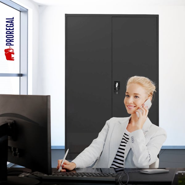 Helles Büro mit großem schwarzen Metallschrank im Hintergrund, Frau am Schreibtisch mit Computer und Proregal Logo.