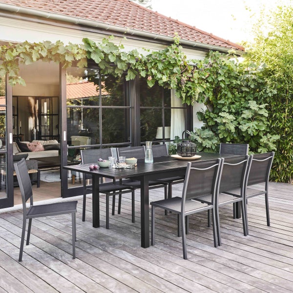 Gartenmöbel-Set bestehend aus einem großen rechteckigen Tisch mit Lattenoptik und acht Gartenstühlen mit Textilbespannung.