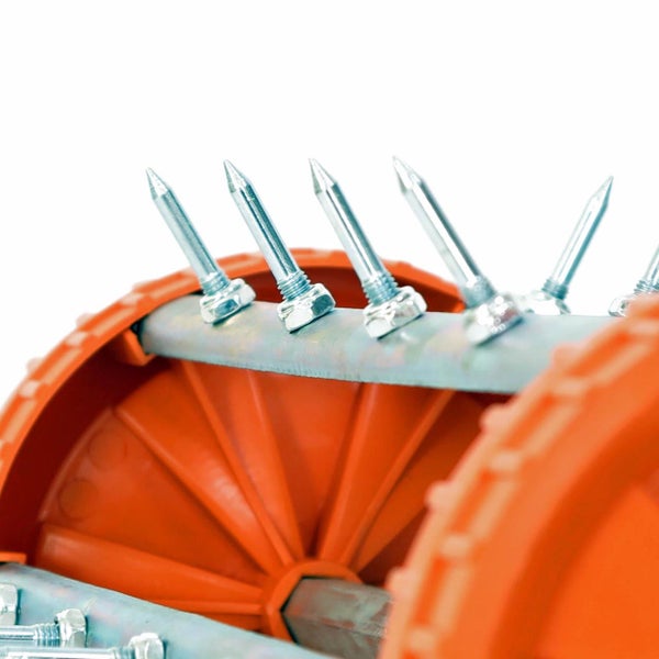 Detailansicht eines Rasenlüfters mit Metallspikes auf einer Metallstange und Kunststoffrädern.