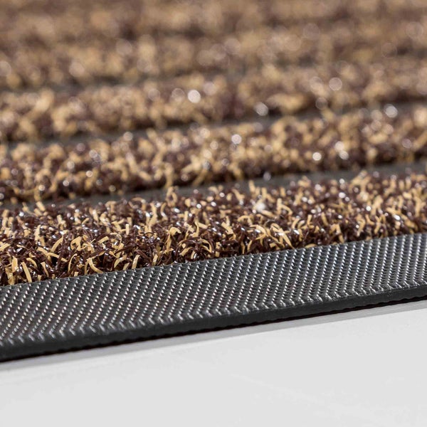 Detailaufnahme einer Fußmatte mit braunen und beigen Fasern und schwarzer Rückseite