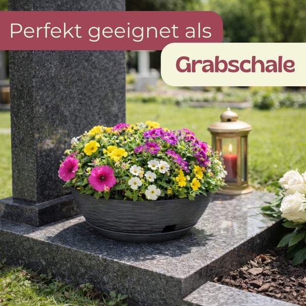 Gedenkschale mit Blumen auf einem Grabstein