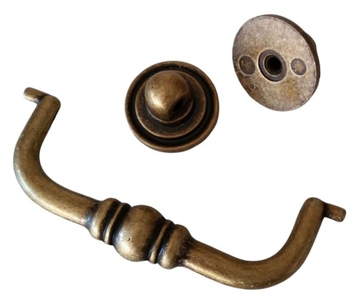 Ein antiker Möbelgriff mit zwei passenden runden Rosetten aus Metall für Schränke oder Schubladen.