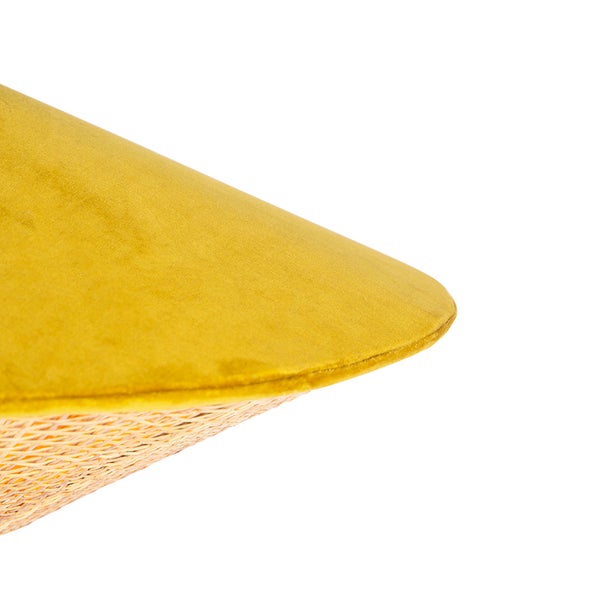 Gelbes Samtkissen mit geflochtener Unterseite in Nahaufnahme.