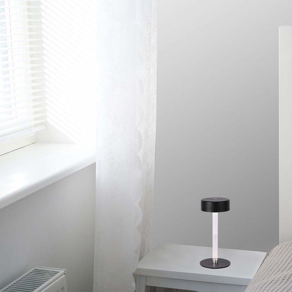 Dekorative Tischleuchte auf einem Nachttisch in einem hellen Schlafzimmer.