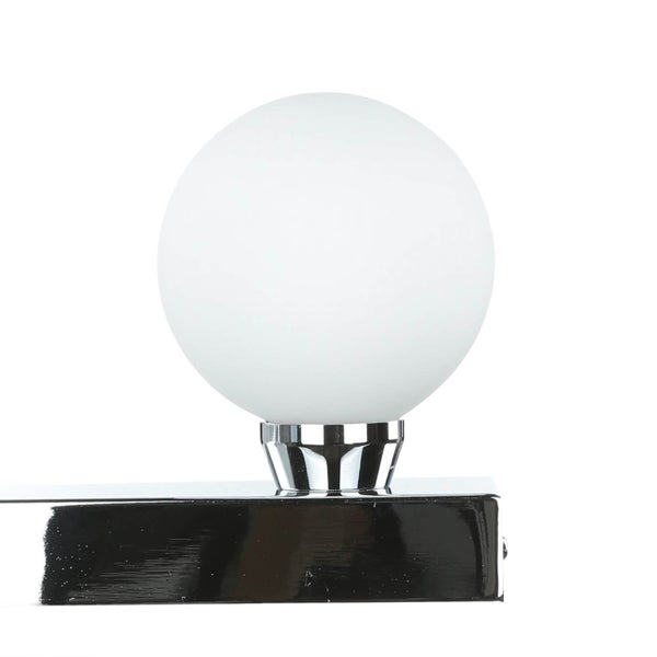 Detailaufnahme einer Wandleuchte mit runder, weißer Glühbirne und verchromter Halterung