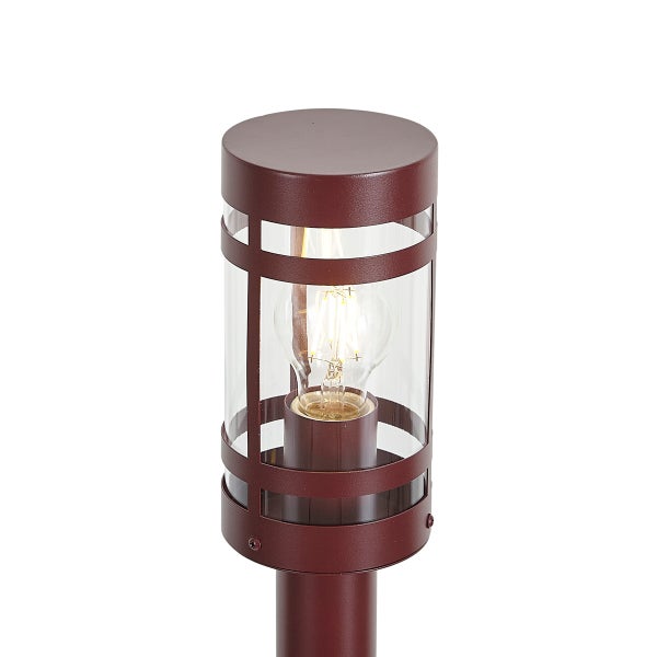 Zylindrische Außenleuchte aus rotbraunem Metall mit Glaseinsatz und sichtbarem Leuchtmittel.