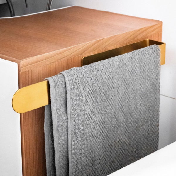 Handtuchhalter aus Metall montiert an einem Badezimmerschrank mit Holzoptik und aufgehängtem Handtuch