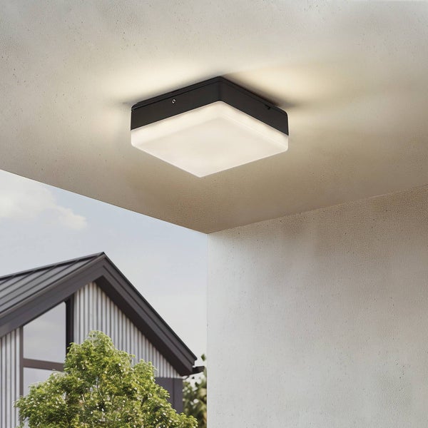 Quadratische Außen-Deckenleuchte mit schwarzem Metallgehäuse und weißem Kunststoffschirm, eingeschaltet an einer Decke montiert.