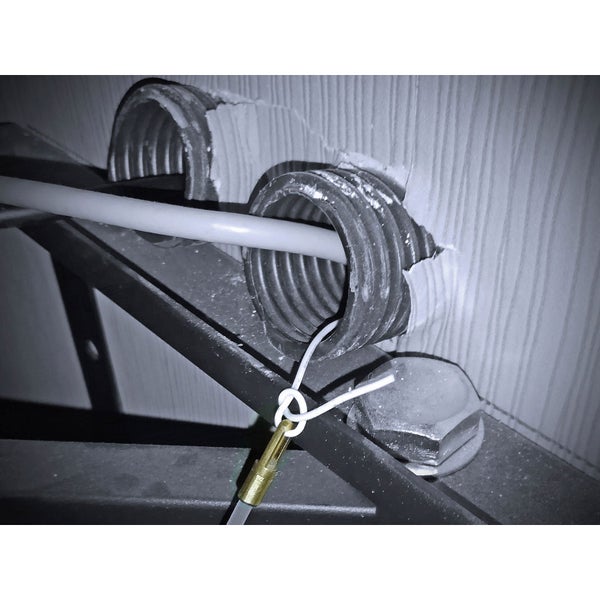 Installation eines Kabels mit Kabelschutzrohr an einer Wand