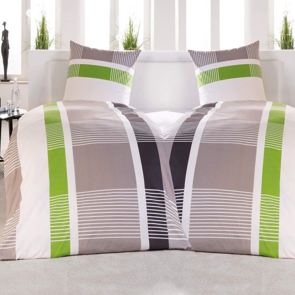 Gestreifte Bettwäsche auf einem Doppelbett in einem hellen, modern eingerichteten Schlafzimmer.