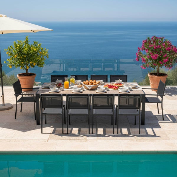 Modernes Gartenmöbel-Set bestehend aus einem großen Esstisch und zehn schwarzen Stühlen auf einer Terrasse mit Pool und Meerblick.