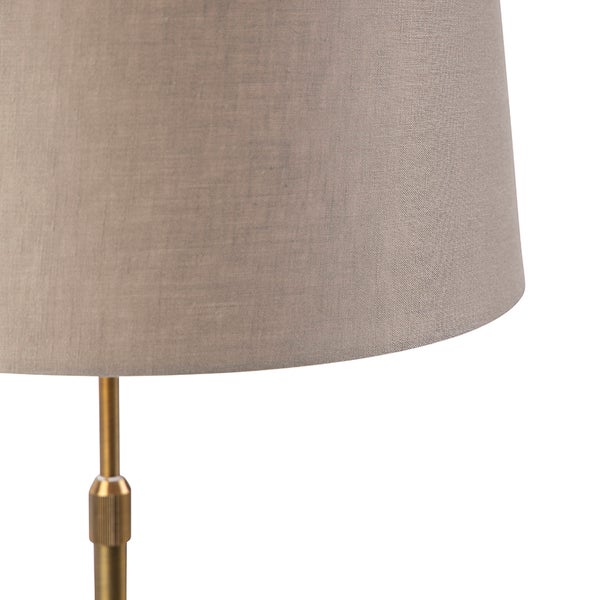 Nahaufnahme eines Textil-Lampenschirms an einem goldfarbenen Metallgestell.