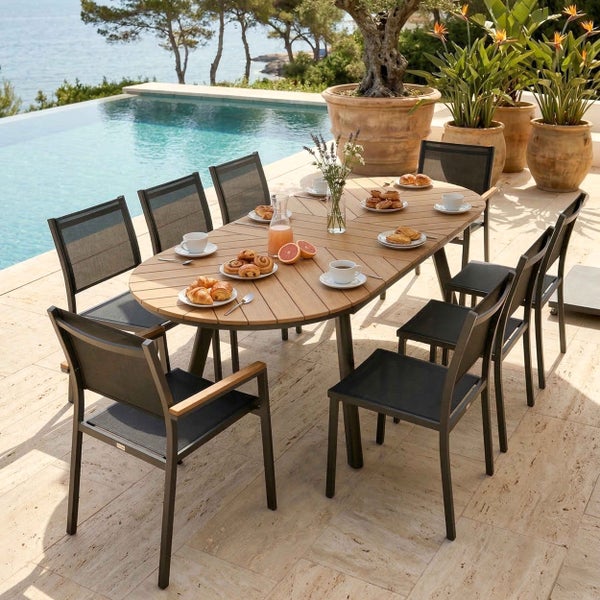 Moderne Garten-Sitzgruppe mit ovalem Holztisch und acht dunklen Stühlen auf einer hellen Steinterrasse neben einem Pool.