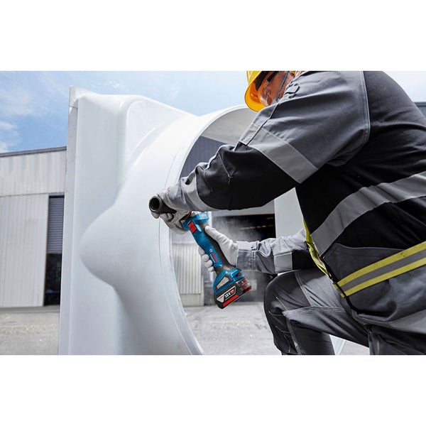 Ein Arbeiter benutzt einen Akku-Winkelschleifer an einem Werkstück.