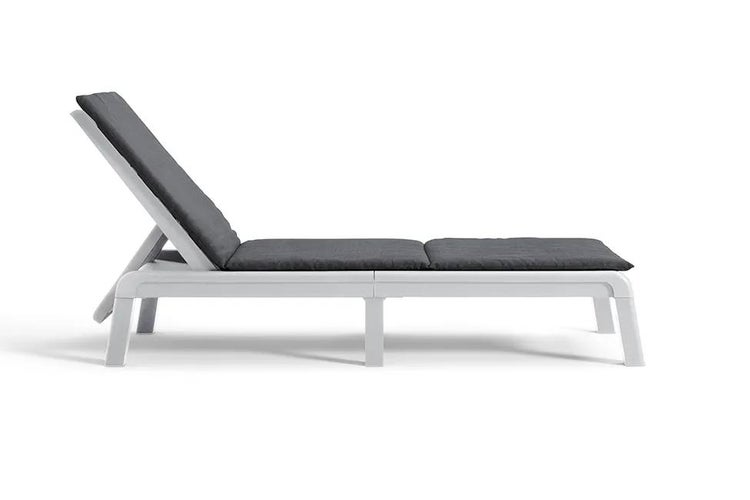 Weiße Sonnenliege mit dunkelgrauer Polsterauflage und verstellbarer Rückenlehne.