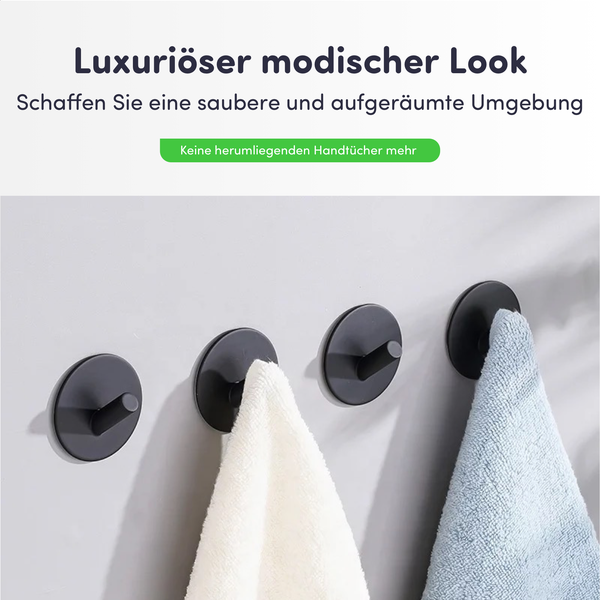Vier runde schwarze Wandhaken mit einem weißen und einem hellblauen Handtuch. Moderner Look für eine aufgeräumte Umgebung.
