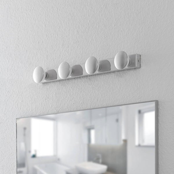 Wandleuchte mit fünf Leuchten über einem Spiegel im Badezimmer.