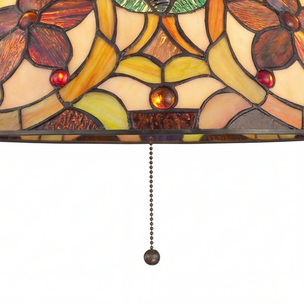 Nahaufnahme eines Tiffany-Lampenschirms aus Glas mit Blumenmuster und einer Zugkette aus Metall.