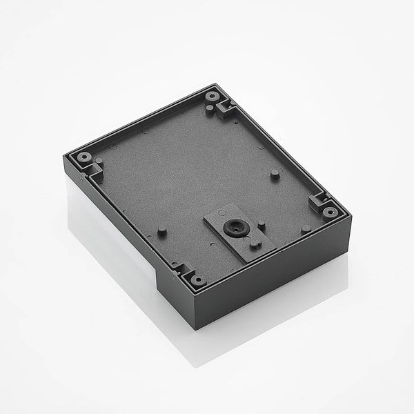Schwarze, rechteckige Montagehalterung mit Befestigungslöchern und Gummidichtung für die Kabeleinführung.